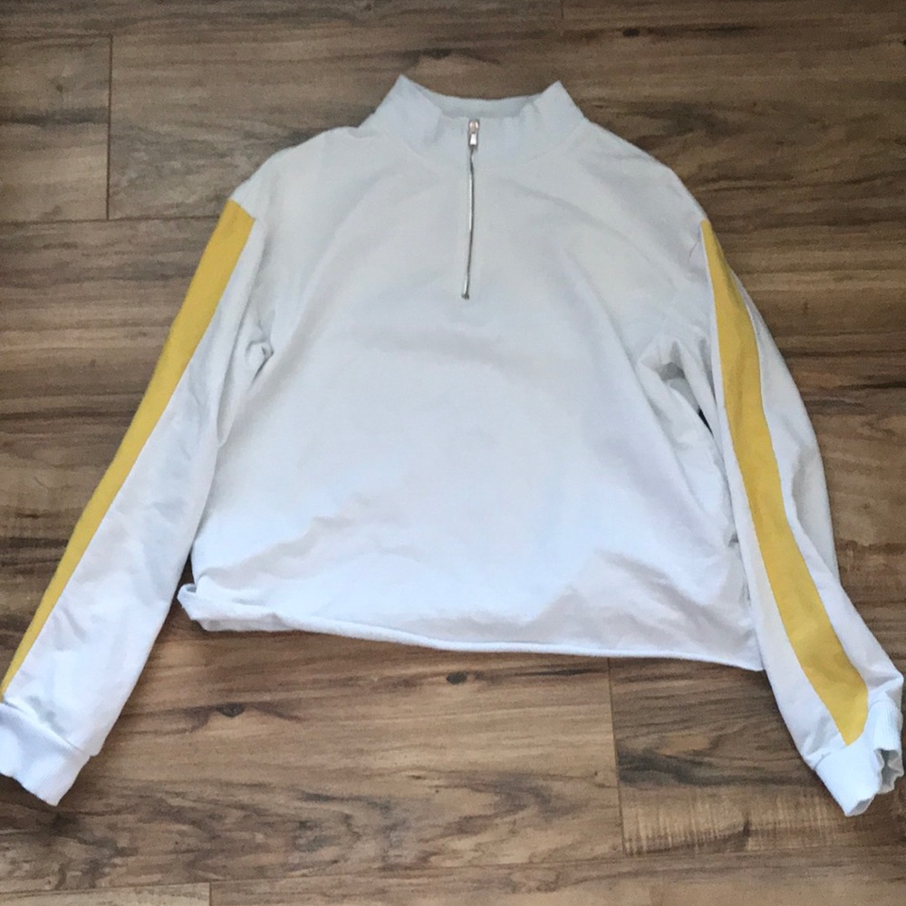 white top with a yellow strip down the sleeve
